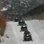 A Train of Snowmobile Riders