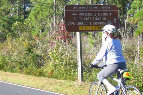 Biking past Directional Sign in Cape Lookout National Seashore