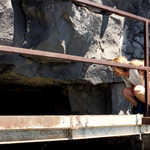 Visitor Peers into Tunnel Carved into Lava Flow