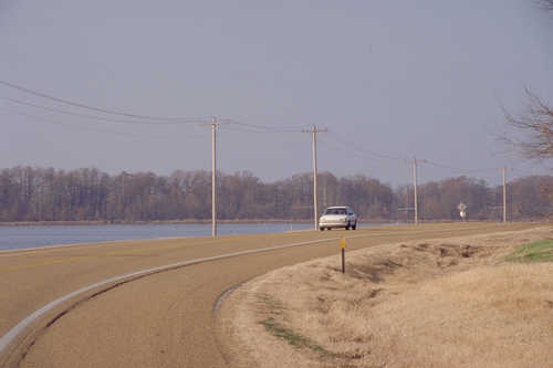 Car Passing a Lake on the Great River Road in Arkansas