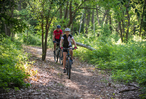 Cyclists ride on the Arkansas River off-road bike route in Ellinwood, Kansas.