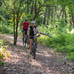 Cyclists ride on the Arkansas River off-road bike route in Ellinwood, Kansas.
