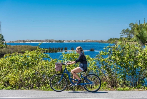 A bicyclist rides past a coastal dune lake on Scenic 30A in Walton County, Florida