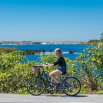A bicyclist rides past a coastal dune lake on Scenic 30A in Walton County, Florida