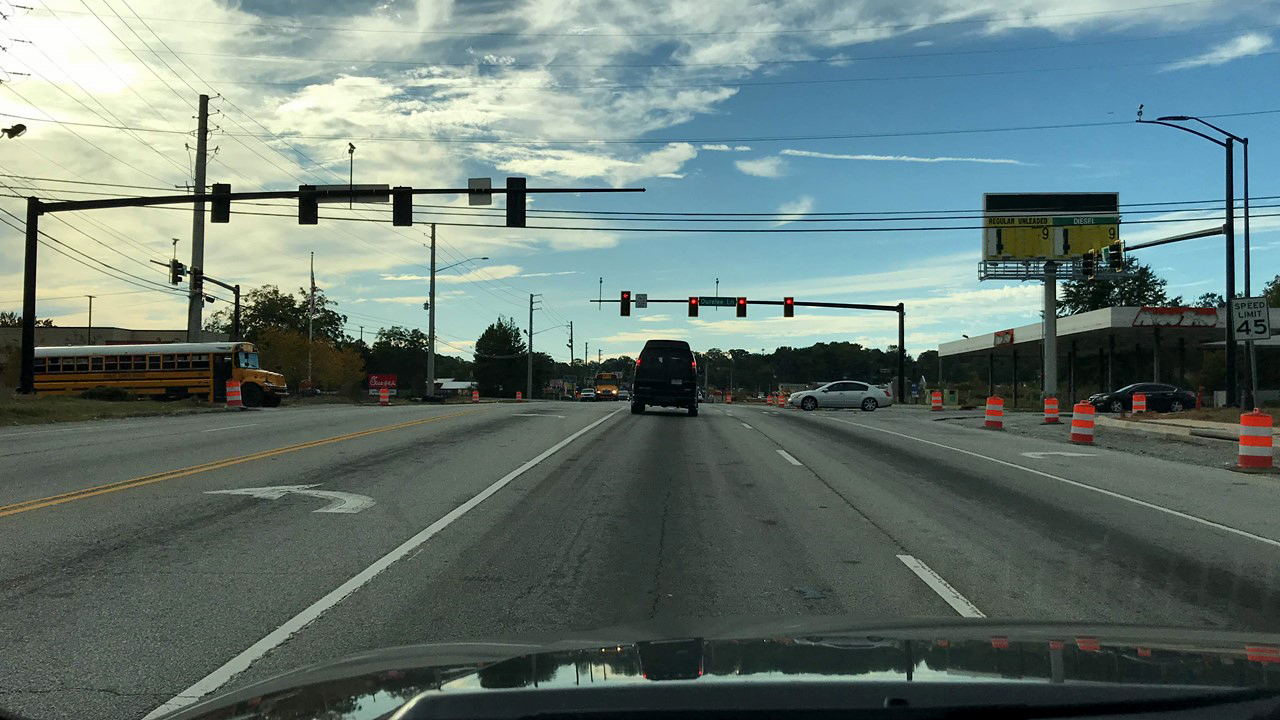 Image Slide from Influence of Context on Traffic Signal Operational Objectives presentation. 
                                        Picture 1 of 3 consecutive intersections where the driver experiences red lights 
                                        Context:
                                        network – arterial
                                        Land use -residential, commercial, retail
                                        Time of day – PM
                                        Traffic conditions – moderate 
                                        
                                        