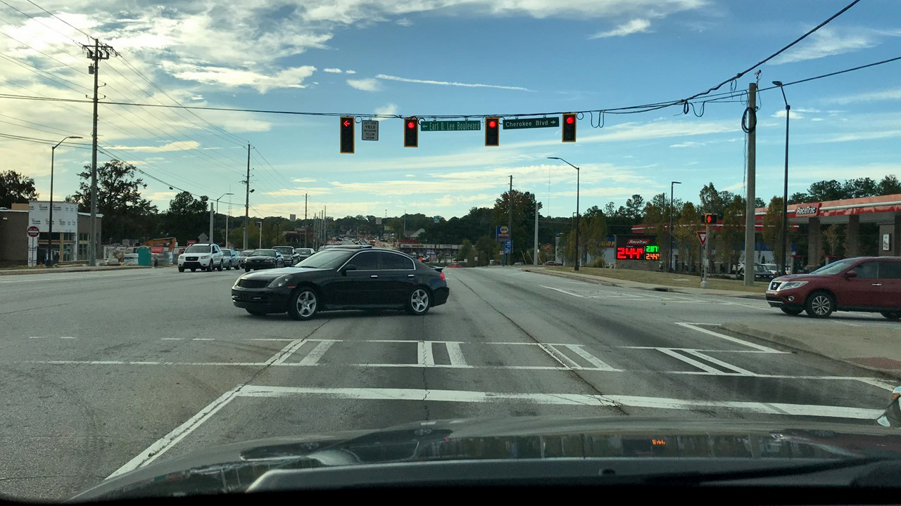 Image Slide from Influence of Context on Traffic Signal Operational Objectives presentation. 
                                        Picture 2 of 3 consecutive intersections where the driver experiences red lights 
                                        Context:
                                        network – arterial
                                        Land use -residential, commercial, retail
                                        Time of day – PM
                                        Traffic conditions – moderate 
                                        
                                        