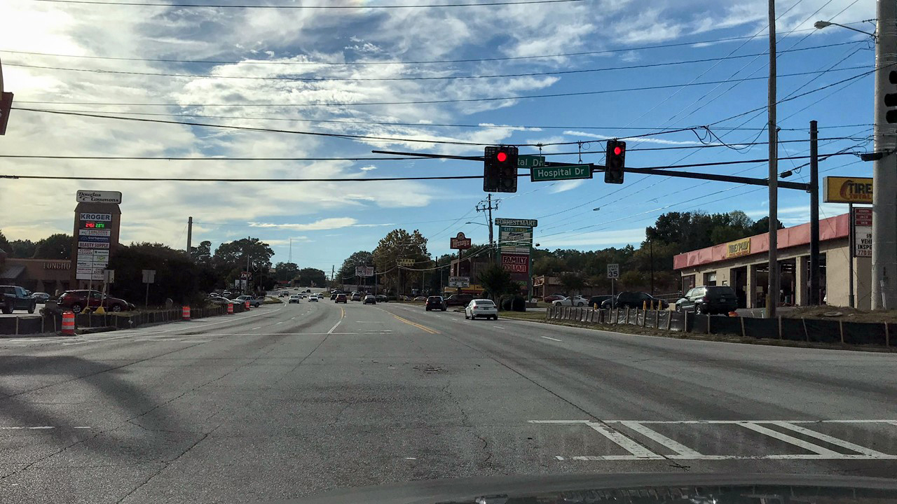 Image Slide from Influence of Context on Traffic Signal Operational Objectives presentation. 
                                        Picture 3 of 3 consecutive intersections where the driver experiences red lights 
                                        Context:
                                        network – arterial
                                        Land use -residential, commercial, retail
                                        Time of day – PM
                                        Traffic conditions – moderate 
                                        
                                        